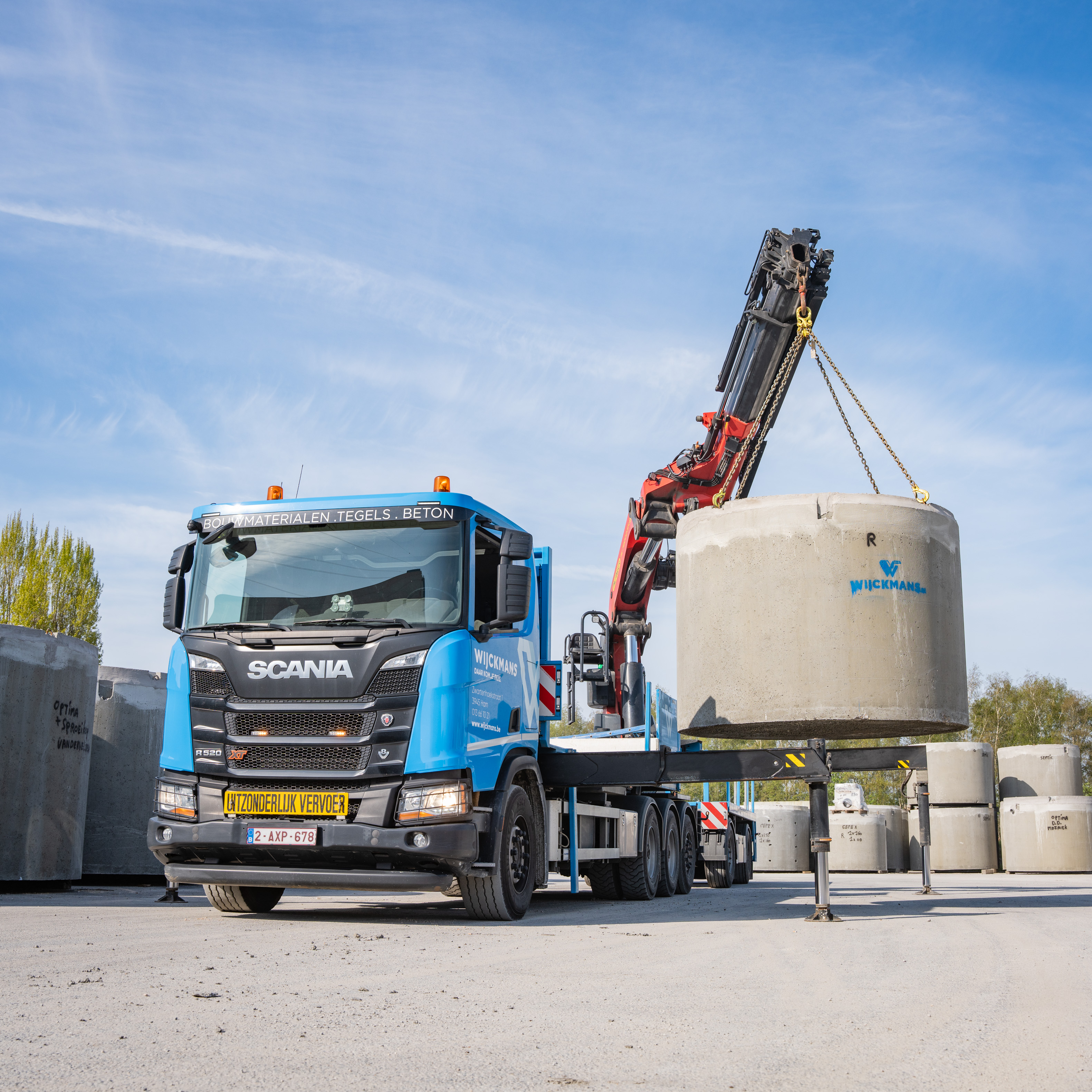Een vrachtwagen van Wijckmans tilt een infiltratieput op met een kraan.